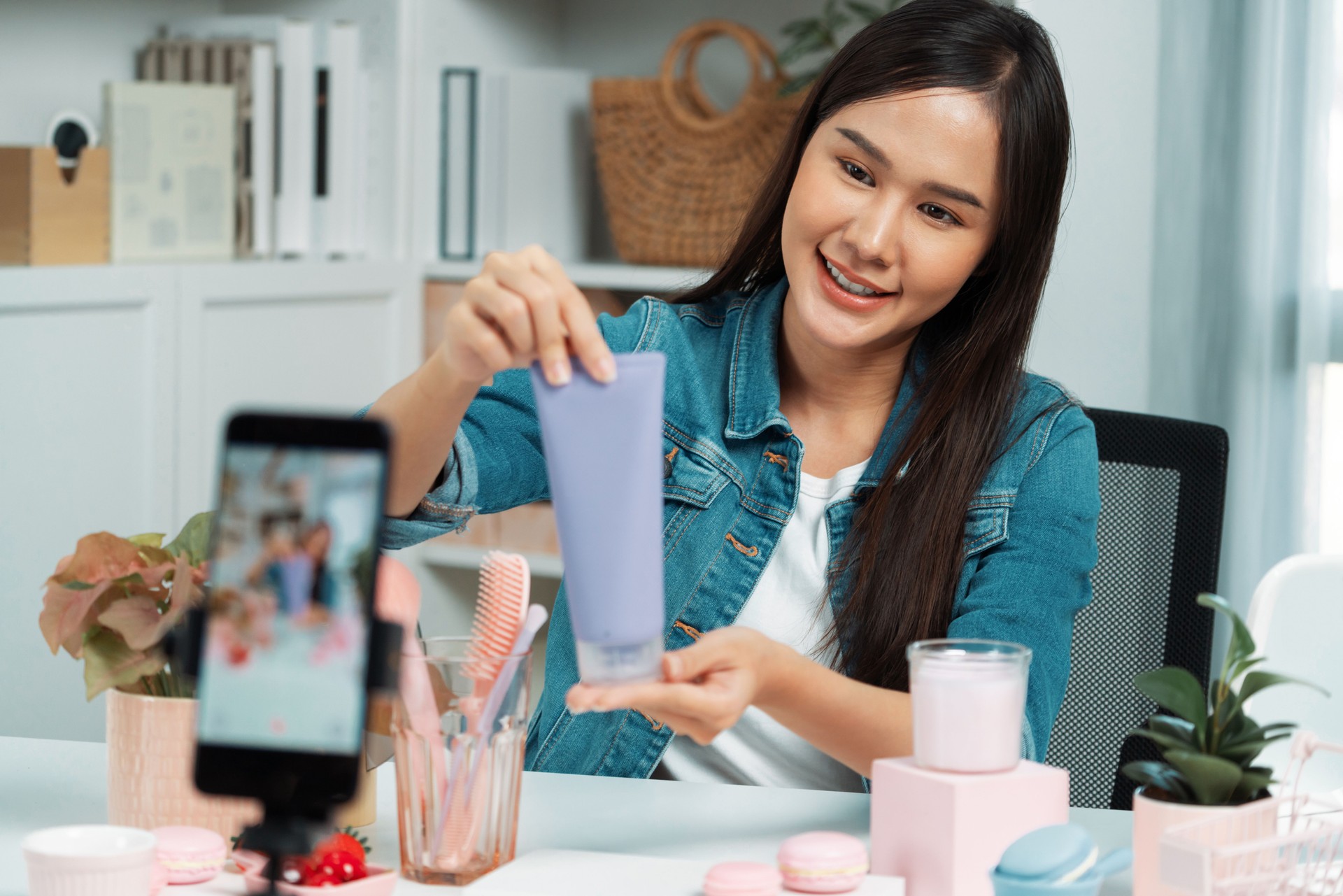 Asian girl reviewing moisturizing cream product to make glowing skin. Stratagem.